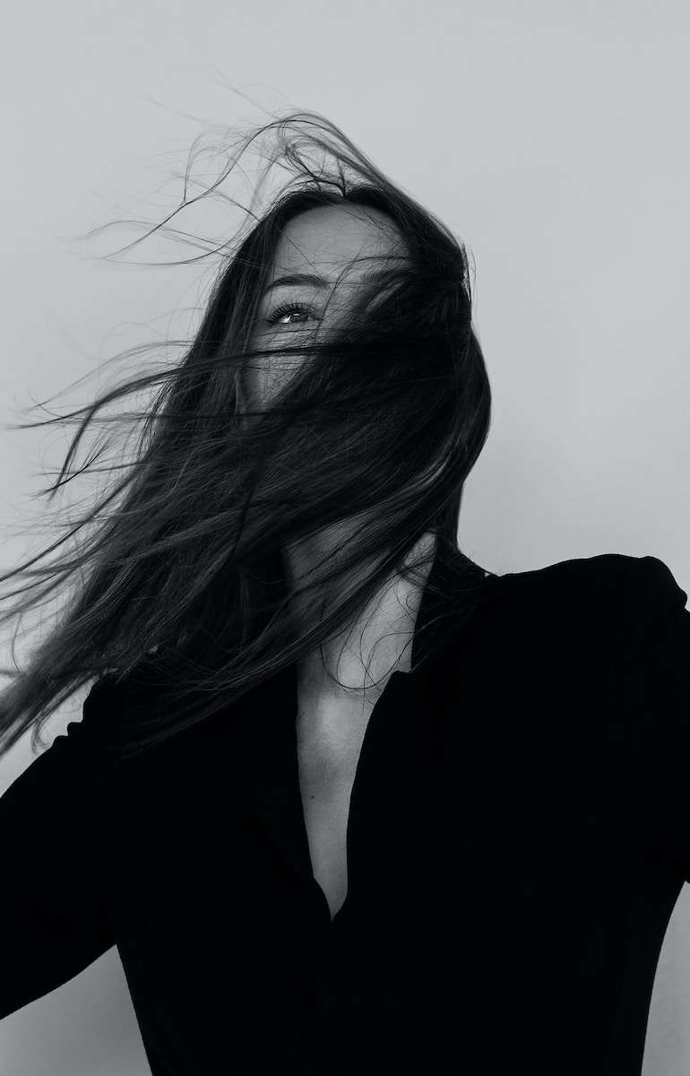 grayscale photography of woman wearing long-sleeved shirt